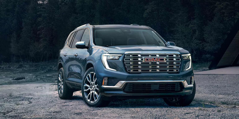 a blue 2026 GMC Acadia is parked near trees in Concord, NC