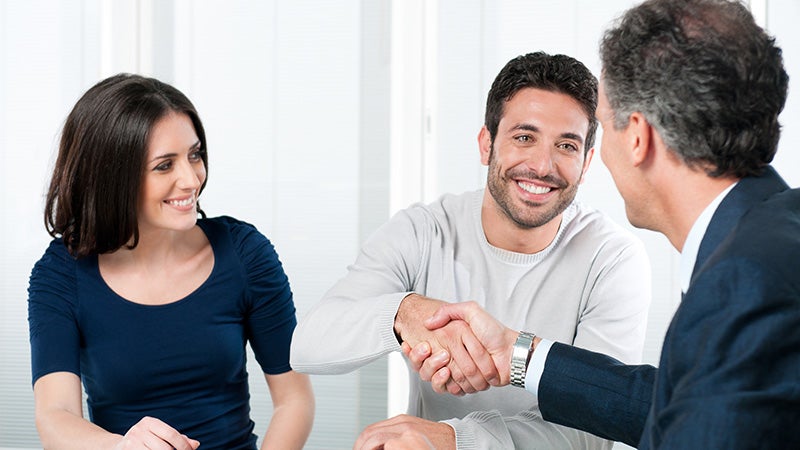 A man shaking hands with a car dealer